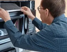 Appliance repair technician replacing a microwave vent filter in Savannah, GA