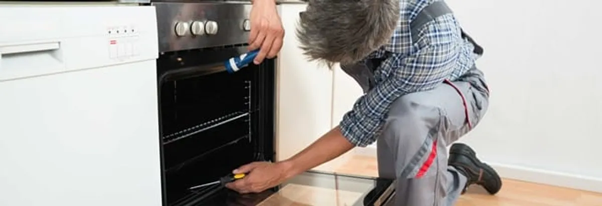 Oven repair technician inspecting and servicing an electric oven in Savannah, GA