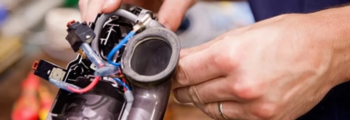 Vacuum repair technician reconnecting wiring and components in Savannah, GA