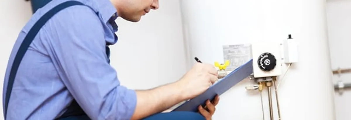Water heater repair technician inspecting the unit and recording service notes in Savannah, GA